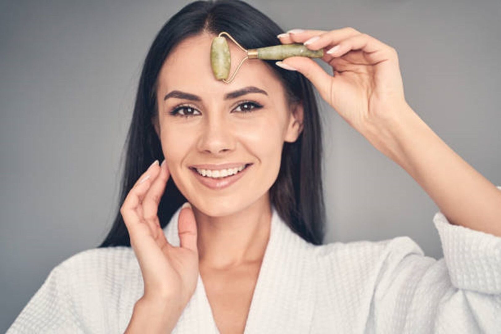 A woman is holding up an avocado to her face.