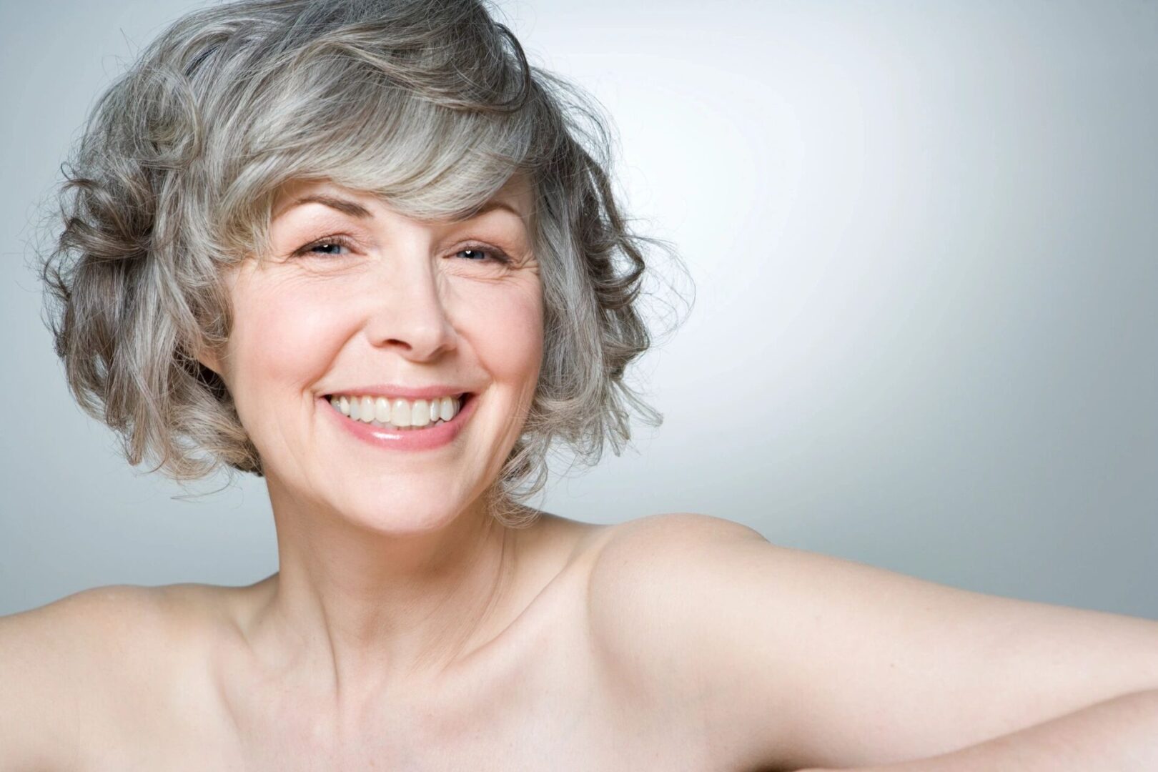 A woman with grey hair smiling for the camera.