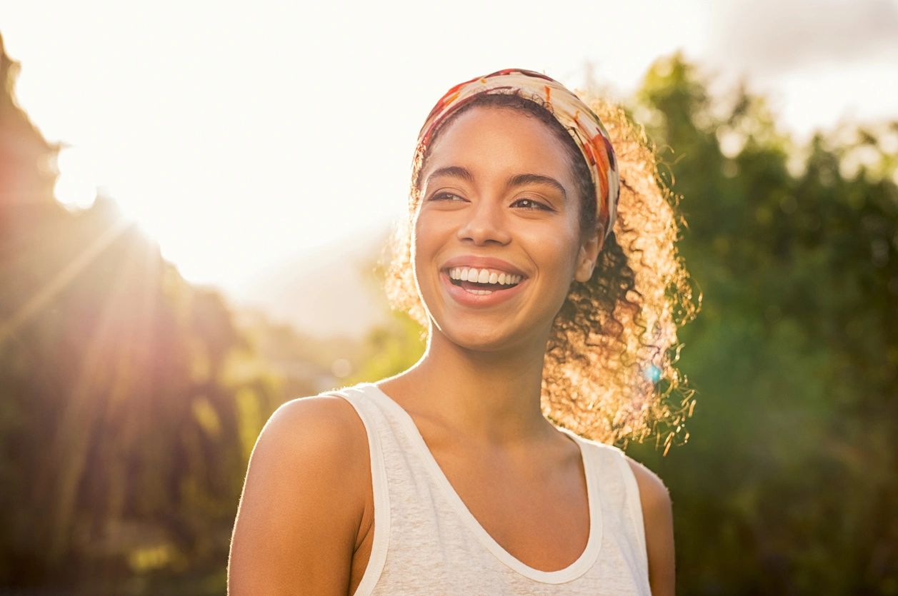 A woman with curly hair smiling for the camera.