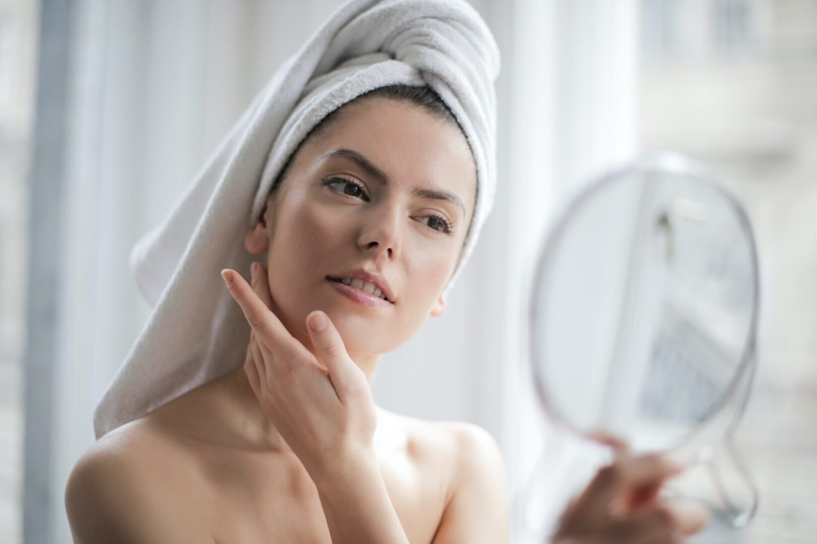 A woman with a towel wrapped around her head and shoulders.